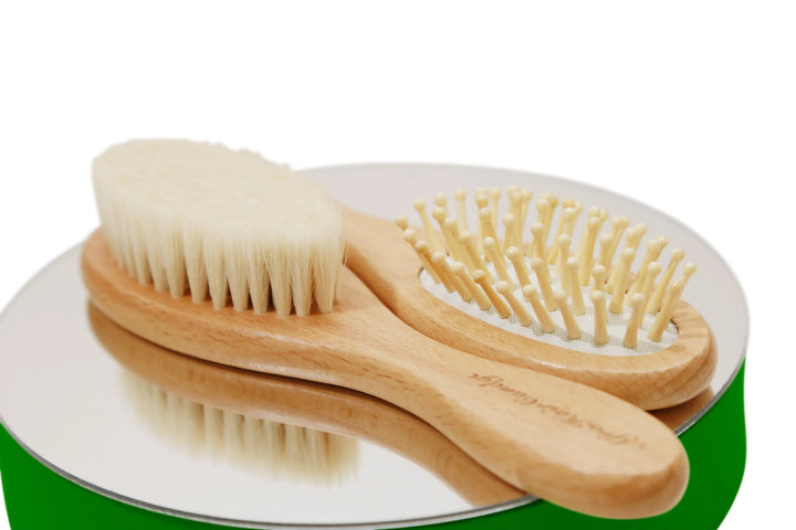 Eco-friendly bamboo comb, goat hair brush, and wooden bristle brush for baby hair care.